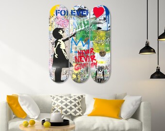 May include: Three skateboard decks mounted on a wall, each with unique graffiti art. The left deck features a silhouette of a girl reaching out, the middle deck has a crown, and the right deck has a red heart. Text includes "FOREVER" and "NEVER GIVE UP".
