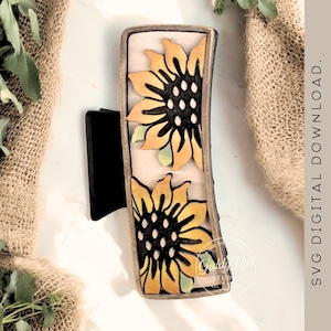 May include: A rectangular wooden hair clip featuring two yellow and black sunflowers with green accents. The clip has a black base and a light beige background. The text "SVG DIGITAL DOWNLOAD. NO PHYSICAL ITEM WILL BE SENT." is visible.