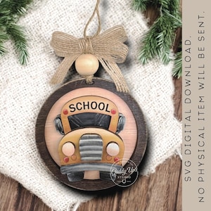 May include: A round wooden ornament featuring a yellow school bus illustration with the word SCHOOL printed above the windshield. The ornament is topped with a natural tan jute twine bow and a small wooden bead, hanging from a loop of twine.