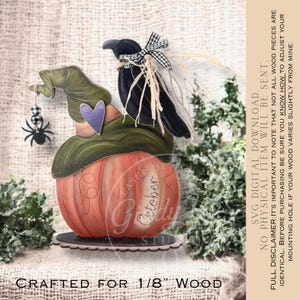 Puede incluir: Decoración de Halloween de madera con una calabaza naranja, un sombrero de bruja verde y un cuervo negro. La calabaza tiene la palabra "October". Una araña negra cuelga del sombrero. La base es festoneada.