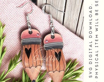 May include: A pair of dangling earrings shaped like pencils with pink erasers, grey ferrules, and orange wooden bodies featuring black heart illustrations. The earrings have silver-toned metal hooks. Text reads: SVG DIGITAL DOWNLOAD. NO PHYSICAL ITEM WILL BE SENT.