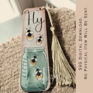 May include: A rectangular wooden bookmark featuring the word Fly in black script, illustrations of fireflies, and a mason jar filled with fireflies. A tan tassel is attached to the top. Text on the right reads SVG DIGITAL DOWNLOAD. NO PHYSICAL ITEM WILL BE SENT.
