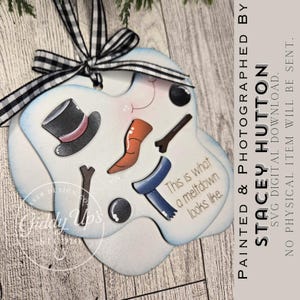 May include: A snowman-themed ornament with a black and white checkered ribbon. The ornament features a top hat, carrot nose, twig arms, and a blue scarf. Text on the ornament reads "This is what a meltdown looks like."