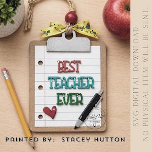 May include: A clipboard-shaped teacher appreciation ornament with the words "BEST TEACHER EVER" in colorful letters. A red heart and a black pen are also on the clipboard. A yellow ribbon with the words "days" and "day" is attached to the top.