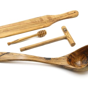 Könnte beinhalten: Set aus vier Küchenutensilien aus Olivenholz: ein großer Holzlöffel, ein kleiner Holzlöffel, ein Honiglöffel aus Holz und ein Nudelholz aus Holz.