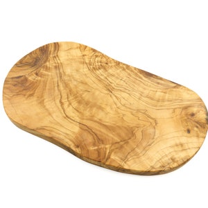 Puede incluir: Una tabla de servir de madera natural con una forma orgánica única y un color marrón claro. La tabla tiene un hermoso patrón de veta y es perfecta para servir queso, embutidos u otros aperitivos.