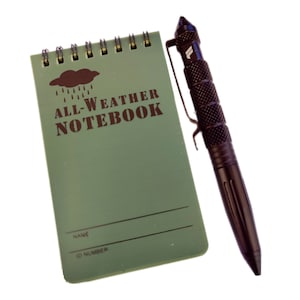 May include: A green all-weather notebook with a black spiral binding and a black pen with a clip. The notebook has the words "ALL-WEATHER NOTEBOOK" printed on the front. The notebook has a space for a name and ID number.