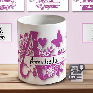 May include: White ceramic mug with a large magenta letter "A" decorated with flowers, butterflies, and the name "Annabella". The mug is shown with other letter designs and text that reads "26 MUG Wrap", "11 OZ & 15 OZ", and "Digital Mug Wrap PNG".