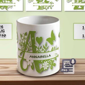 May include: White ceramic mug with a green floral and butterfly design, featuring the letter "A" and the name "Annabella". The mug is available in 11 oz and 15 oz sizes. Additional designs with other letters are also shown.