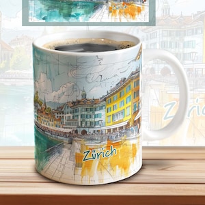 May include: White ceramic coffee mug with a watercolor illustration of the city of Zurich, Switzerland. The mug has a black rim and handle. The illustration features buildings, a river, and the word "Zürich" in yellow.