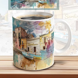 May include: A white ceramic mug with a watercolor design of a colorful Italian village with boats in the harbor. The mug has the word "Sardinien" written on it.