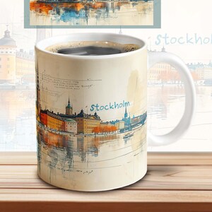 May include: White ceramic coffee mug with a watercolor illustration of the Stockholm skyline. The mug has a black handle and the text "Stockholm" is printed on the front.