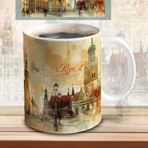 May include: White ceramic mug with a colorful illustration of the city of Riga, Latvia. The mug features a watercolor-style painting of buildings, streets, and a lamppost. The word "Riga" is written in cursive on the mug.