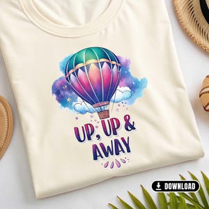 Könnte beinhalten: Ein cremefarbenes T-Shirt mit einem Aquarell-Design eines Heißluftballons mit dem Text "Up, Up & Away" auf der Vorderseite.