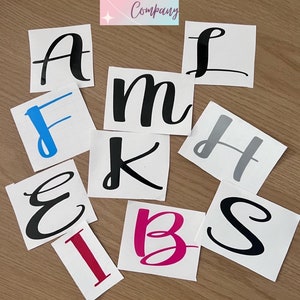 May include: A selection of vinyl letter stickers in various colours and fonts. The letters include A, L, F, m, H, E, K, I, B, and S. The stickers are on white squares, with the text "Sparkle Dust Company" at the top.