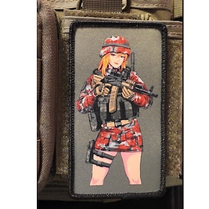 May include: A rectangular morale patch featuring a printed illustration of a character wearing a red and gray camouflage helmet, jacket, and skirt. The character holds a black rifle and wears a tactical vest over the camouflage clothing.