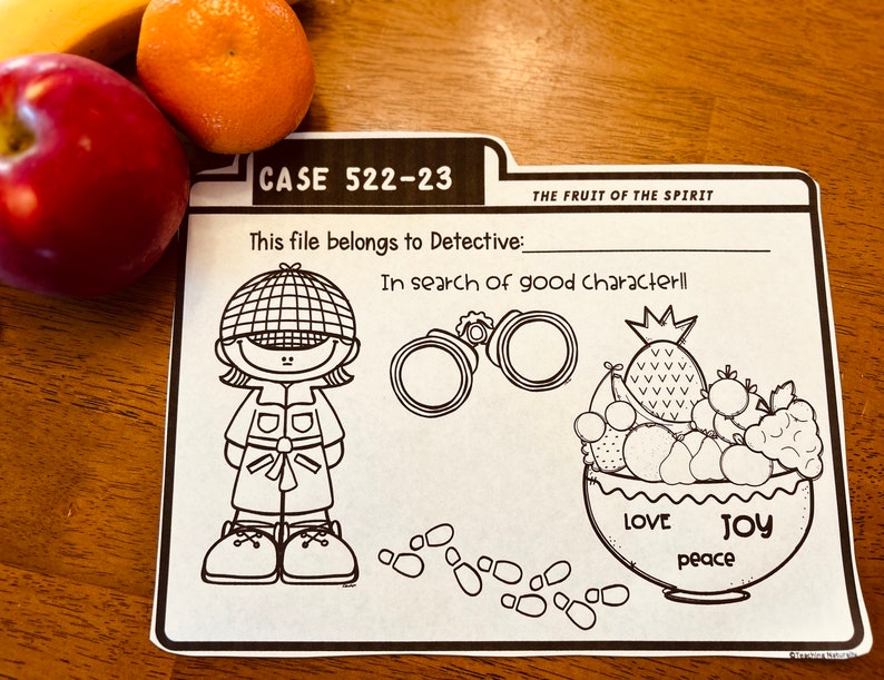 May include: Black and white printable worksheet with a detective character, magnifying glass, and a bowl of fruit. The text reads "CASE 522-23", "This file belongs to Detective:", "THE FRUIT OF THE SPIRIT", "In search of good characterll", "LOVE", "JOY", and "peace".