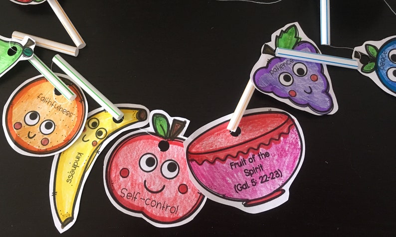 May include: A colorful fruit-themed garland with a bowl that says "Fruit of the Spirit (Gal 5: 22-23)" and individual fruits with words like "faithfulness", "kindness", "self-control", and "patience".