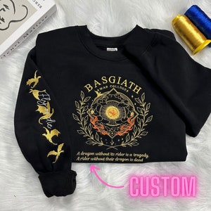 May include: Black sweatshirt with gold embroidery of a dragon and the text "BASGIATH +WAR COLLEGE" and "A dragon without its rider is a tragedy. A rider without their dragon is dead".