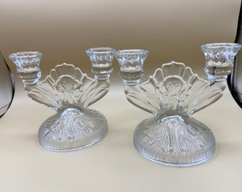 May include: Two clear glass candle holders with a floral design. Each holder has three candle cups.
