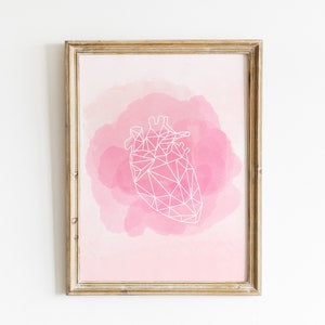 Könnte beinhalten: Ein gerahmter Druck mit einem geometrischen Herzdesign in Weiß auf einem rosa Aquarellhintergrund.