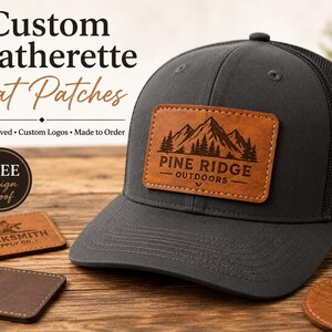 May include: A dark gray trucker hat with a rectangular brown leatherette patch featuring a laser-engraved mountain range and the text PINE RIDGE OUTDOORS. Additional leatherette patches with various logos are displayed nearby on a wooden surface.