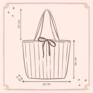 May include: A line drawing of a tote bag with vertical stripes and a center bow. The bag measures 40 cm in height, 45 cm in width, and 8 cm in depth, with a total height of 60 cm including the handles. The illustration is set on a light background.