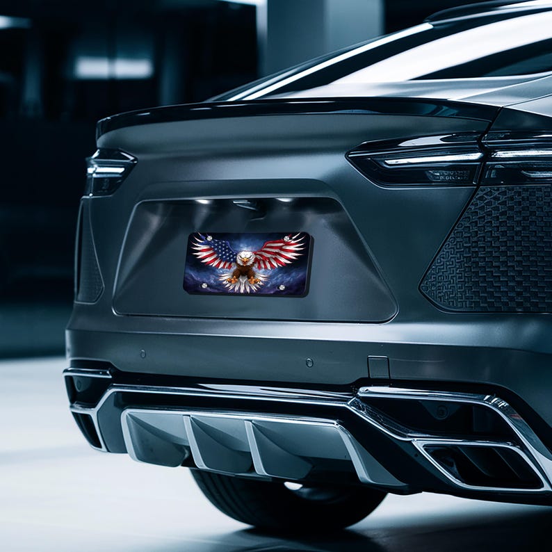 May include: A black car with a license plate featuring an American bald eagle with its wings spread wide, flying over an American flag. The eagle is in front of a blue and white background with stars.