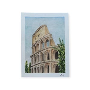 Op de afbeelding: Waterverfschilderij van het Colosseum in Rome, Italië. Het kunstwerk toont het oude amfitheater in tinten beige en bruin, met een lichtblauwe lucht op de achtergrond. Groen gebladerte is zichtbaar aan de rechterkant.