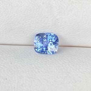 May include: A light blue cushion-cut sapphire gemstone.