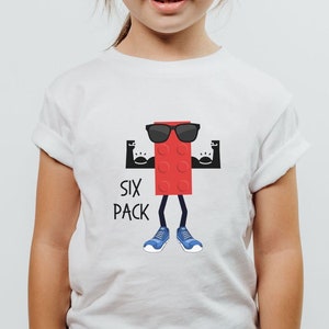 May include: White t-shirt with a red cartoon character wearing sunglasses and flexing its muscles. The text "SIX PACK" is printed below the character.
