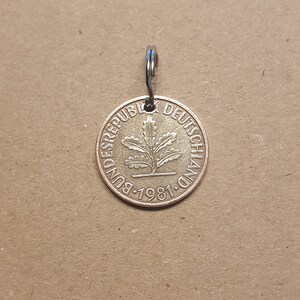 Könnte beinhalten: Ein goldfarbener Münzen-Schlüsselanhänger mit der Aufschrift "BUNDESREPUBLIK DEUTSCHLAND 1981" und einem Eichenblatt-Design.