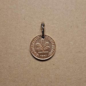 Könnte beinhalten: Eine goldfarbene Münze mit der Aufschrift "Bundesrepublik Deutschland 1981" und einem Eichenblatt-Design.