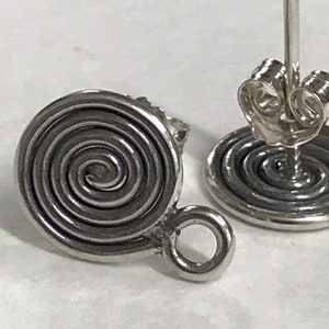 May include: A pair of silver earrings with a spiral design. The earrings have a post back and a small loop on the side.