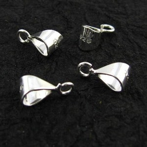 Puede incluir: Cuatro cierres de metal plateados para la elaboración de joyas. Los cierres son de varias formas y tamaños.