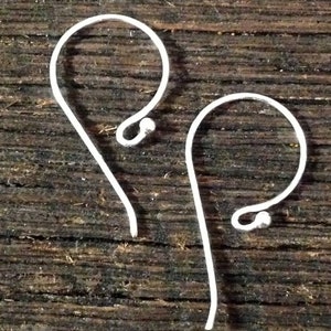May include: Two silver earring hooks, each with a small loop at the top and a slightly larger loop at the bottom.