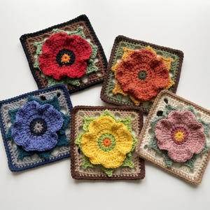May include: Five square crochet motifs featuring three-dimensional flowers in red, orange, blue, yellow, and pink. Each square has a unique color scheme with green leaf accents and a central flower, showcasing intricate yarn work and textured petals.
