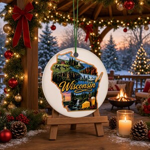 May include: A round white ceramic ornament shaped like the state of Wisconsin, featuring a colorful collage of cows, a lighthouse, a waterfall, a beer glass, and a block of cheese, with the word Wisconsin written in a cursive script font.