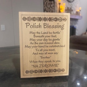 May include: A wooden plaque with the words "Polish Blessing" engraved in a decorative font. The plaque features a poem and the phrase "NA ZDROWIE" at the bottom, surrounded by floral designs.