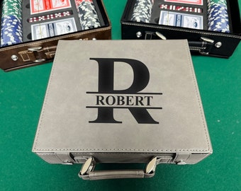 Può includere: Una valigetta grigia per set da poker con il nome "ROBERT" e una grande lettera "R" stampata sul davanti. La valigetta ha una maniglia e finiture color argento. Sullo sfondo sono visibili altri due set da poker.