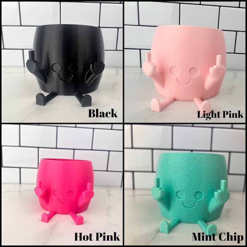 K&ouml;nnte beinhalten: Vier Keramik-Blument&ouml;pfe in verschiedenen Farben: Schwarz, Hellrosa, Pink und Mintchip. Jeder Topf ist in Form einer Cartoonfigur mit zwei Armen, die in einem Mittelfinger-Gestus erhoben sind, und zwei Beinen. Die T&ouml;pfe haben ein Smiley-Gesicht mit zwei Augen und einem Mund.