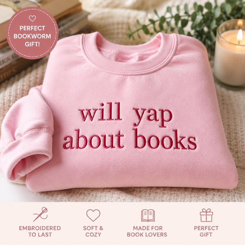 May include: A light pink sweatshirt with the embroidered phrase "will yap about books" in a darker pink. The sweatshirt has a crew neck and long sleeves. The image also includes text that says "Perfect Bookworm Gift!"