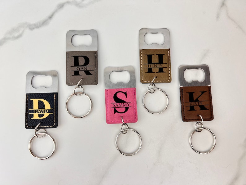 Puede incluir: Cinco llaveros abridores de botellas personalizados con diferentes nombres e iniciales. Los llaveros est&aacute;n hechos de cuero marr&oacute;n con un abridor de botellas plateado. Los nombres son Ryan, Henry, David, Sammy y Kevin.
