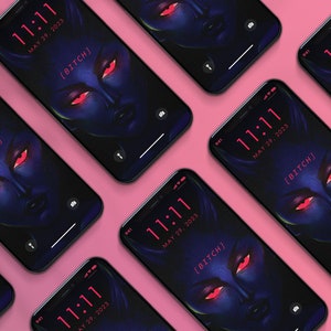 May include: Several smartphones displaying a dark blue and red graphic of a face with red eyes and the word "[BITCH]" on the screen. The time "11:11" and the date "MAY 29, 2023" are also visible. The phones are arranged on a pink surface.