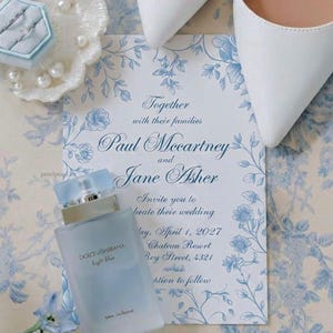 May include: A pair of white pointed-toe heels, a light blue Dolce & Gabbana Light Blue perfume bottle, a ring in a light blue hexagonal box, and a wedding invitation for Paul McCartney and Jane Asher with blue floral illustrations on a patterned surface.