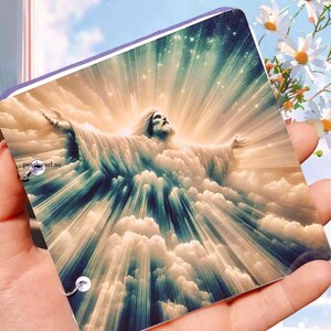 May include: A rectangular print depicting a celestial figure with outstretched arms, surrounded by clouds and light rays. The print has a purple border and the text "pearlpearl au" in the lower left corner.