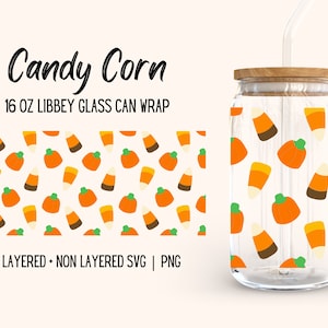Op de afbeelding: Een 473 ml glazen blikverpakking met een patroon van oranje en gele candy corn en oranje pompoenen op een witte achtergrond. De tekst "Candy Corn" en "16 oz LIBBEY GLASS CAN WRAP" staat op de verpakking gedrukt. De tekst "LAYERED + NON LAYERED SVG | PNG" staat ook op de verpakking gedrukt.