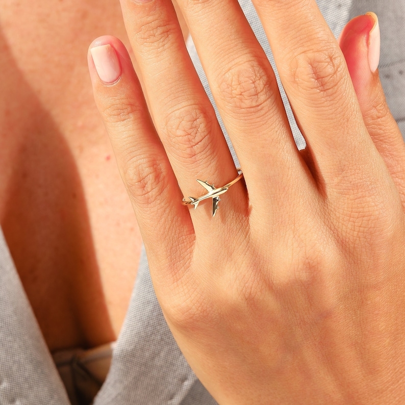 Celebrate your love for adventure with our traveler ring gold, a sleek and meaningful accessory for those always on the move. This stylish airplane ring 14K and Airplane ring gold design is perfect for any female pilot ring or aviation enthusiast. With its minimal plane ring design and elegant 18K stackable ring form, it's ideal for everyday wear. Whether you're looking for something gifted for hostess, travellers jewelry,