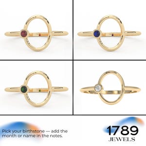 Puede incluir: Cuatro anillos de oro con piedras preciosas de diferentes colores: rojo, azul, verde y transparente. Cada anillo tiene un dise&ntilde;o ovalado con una piedra preciosa en un lado. El texto "Pick your birthstone - add the month or name in the notes." es visible.