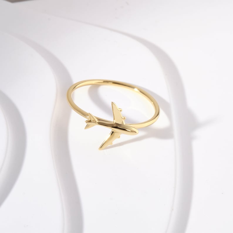Celebrate your love for adventure with our traveler ring gold, a sleek and meaningful accessory for those always on the move. This stylish airplane ring 14K and Airplane ring gold design is perfect for any female pilot ring or aviation enthusiast. With its minimal plane ring design and elegant 18K stackable ring form, it's ideal for everyday wear. Whether you're looking for something gifted for hostess, travellers jewelry,